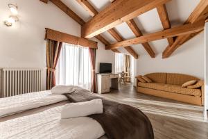 科姆梅扎杜拉Hotel Sasso Rosso的一间卧室配有一张大床和一张沙发