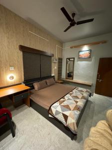 瓦拉纳西Kaashi Flora (2BHK - Ground Floor)的一间卧室配有一张床和吊扇