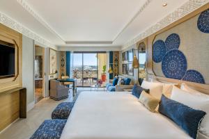 丹吉尔Fairmont Tazi Palace Tangier的酒店客房设有一张大床和一台电视。