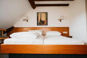 OberstadionBrauereigasthof Adler的一间卧室配有两张带白色枕头的床