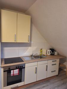杜伊斯堡Zwei Zimmer Wohnung的厨房配有水槽、炉灶和橱柜。