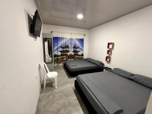 GuayabalJamjali Hotel Armero Guayabal的一间卧室设有两张床、一台电视和一把椅子