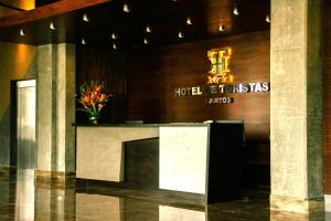 伊基托斯Hotel de Turistas Iquitos的酒店大堂设有前台和标志