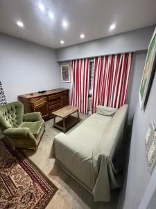 马德普拉塔Habitaciones Garay 3100的一间卧室配有一张床、一张桌子和一把椅子