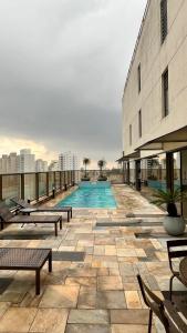 圣保罗Suíte Transamerica Executive Paulista的一座大型建筑,上面设有一个游泳池