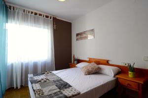 莱斯卡拉Apartamentos Puig Sureda的一间卧室设有一张床和一个窗口