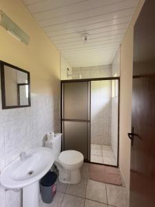 安东尼娜Suítes Romanetto com Piscina e Vista - Antonina的浴室配有卫生间、盥洗盆和淋浴。
