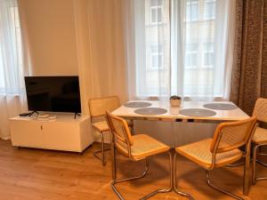 耶拿Appartement House Jena的客厅配有桌椅和电视