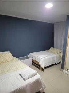 皮斯科CASA MARIA的一间卧室设有两张床和蓝色的墙壁