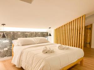 科皮托Wolf House BnB的一间卧室配有一张大床和毛巾