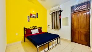 巴加Muffy’s Vacation Apartment的黄色客房的卧室,配有一张床,设有门