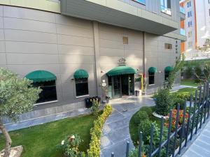 Karaköprü KöyüYOUR HOUSE Apart Otel的享有带绿色遮阳篷的建筑的外部景色