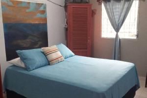 El PorvenirCasa Pico Bonito的一间卧室配有一张带蓝色床单的床和一扇窗户。