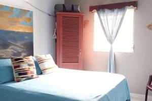 El PorvenirCasa Pico Bonito的一间卧室设有一张床和一个带红色百叶窗的窗户