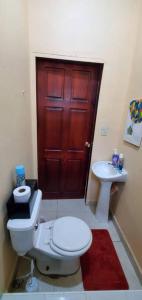 El PorvenirCasa Pico Bonito的一间带卫生间、水槽和红色门的浴室
