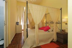 罗马罗坎达阿尔维米纳尔旅馆的一间卧室配有一张带红色枕头的天蓬床