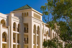 丹吉尔Fairmont Tazi Palace Tangier的一座白色的建筑,上面有一座塔