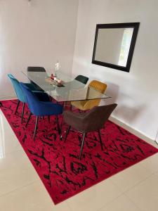 KitweFour m luxury Apartment.的一张带椅子的餐桌和红色地毯