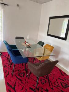 KitweFour m luxury Apartment.的一间设有玻璃桌和椅子的用餐室