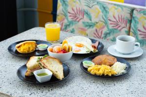 麦德林Mythical Hotel - Boutique的餐桌,早餐盘和橙汁