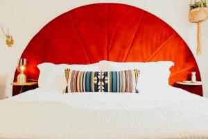 黑利New Downtown Hailey Condo with Rooftop Hot Tub的一间卧室配有红色的大床头板和白色的床