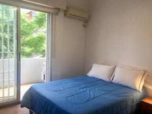 蒙得维的亚Artistes du Monde的一间卧室设有一张蓝色的床和大窗户