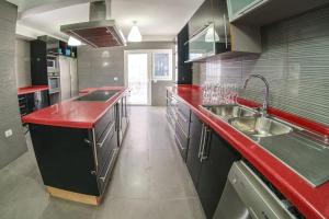 La MaretaVilla Mirador de los Abrigos的一个带红色台面和水槽的大厨房