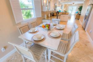 霍姆斯海滩Pineapple Key的厨房里配有餐桌和椅子