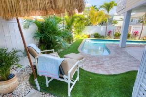 霍姆斯海滩Pineapple Key的一个带椅子的庭院和一个游泳池