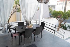 新马克立Seaside House in Nea Makri的天井上的黑色餐桌和椅子