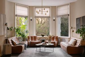 阿姆斯特丹Sonder Park House的客厅配有皮革家具和窗户。