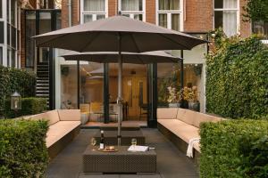 阿姆斯特丹Sonder Park House的坐在庭院桌子上的雨伞