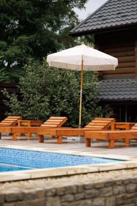 NeporotovoWild River的一个带长椅和遮阳伞的庭院,毗邻游泳池