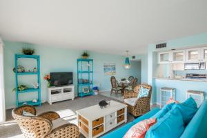 布雷登顿海滩Sunset Terrace 104的客厅配有蓝色的沙发和椅子