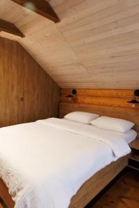 NeporotovoWild River的卧室配有一张白色大床和木墙