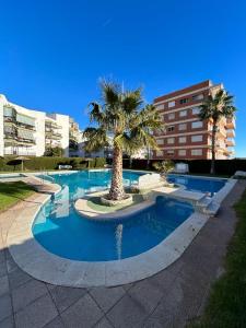 贝尼卡西姆Apartamento Benicàssim Sunset Calm&Views的一座棕榈树和建筑的游泳池