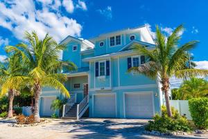 霍姆斯海滩Tiki Beach的一座棕榈树的蓝色房子