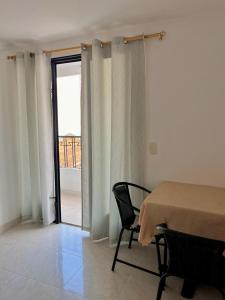 OcañaHotel San Cayetano的客房设有桌子和享有美景的窗户。