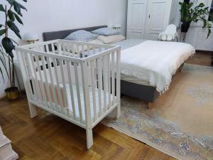 布达佩斯Allomas Apartman的一间卧室配有婴儿床和一张地毯床。