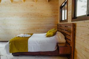 圣赫拉多德多塔Cabinas El Quetzal的卧室配有木墙内的一张床