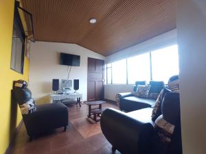 通哈Apartamentos Casa MJ Tunja的客厅配有两张沙发和一台电视机