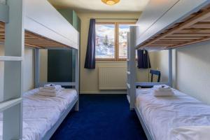 拉普拉涅ho36 La Plagne的一间卧室设有两张双层床和一扇窗户。