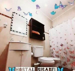 蒂诺加斯塔Hostal Sisabel的浴室设有卫生间,墙上挂有蝴蝶。