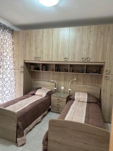 艾因西莱姆Orchidea Appartment的配有木柜的客房内的两张床