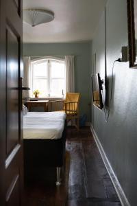 里伯Cafe Sallys bed and breakfast的一间卧室配有一张床、一张桌子和一个窗户。