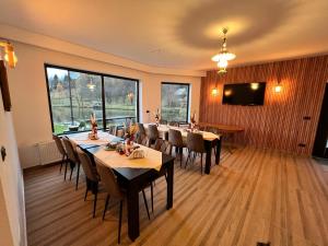 博尔沙Pensiunea Lacul Arșiței的用餐室配有桌椅和平面电视。