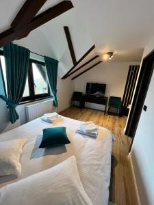 博尔沙Pensiunea Lacul Arșiței的卧室配有带绿色枕头的大型白色床