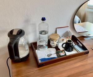 普里什蒂纳Convini Bed & Bathroom Homestay的一个带一瓶水和镜子的木制托盘