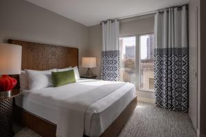 圣安东尼奥Hotel Contessa - Suites on the Riverwalk的一间卧室设有一张大床和一个大窗户