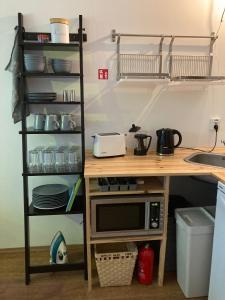 柏林Minimal Hostel No 41的厨房配有带微波炉和架子的桌子